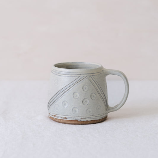 Handmade ceramic mug in soft yellow with a handle